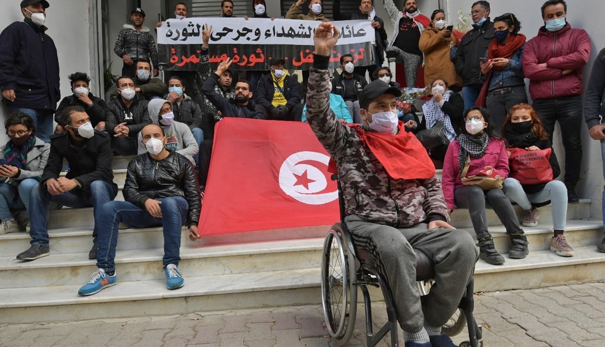 شاب تونسي أصيب خلال الثورة يردد هتافات مناهضة للحكومة خلال اعتصام في العاصمة تونس (14 ك2 2021، أ ف ب). 