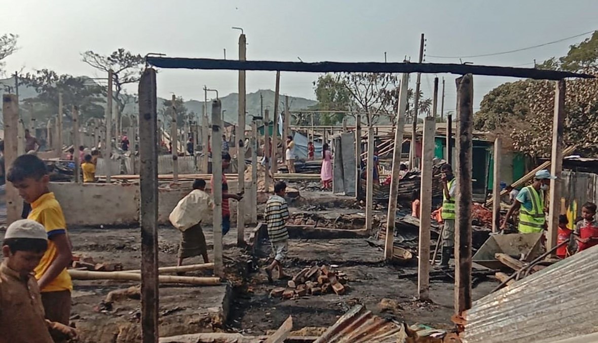 لاجئون من الروهينغيا يبحثون عن ممتلكات نجت من الحريق الذي اندلع في مخيم نايابارا للاجئين في تكناف (14 ك2 2021، أ ف ب).