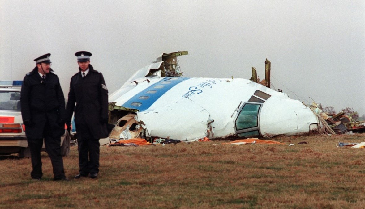  شرطيان يقفان بالقرب من حطام طائرة ركاب "بانام 747" التي انفجرت وتحطمت في لوكربي باسكتلندا (22 ك1 1988، أ ف ب). 