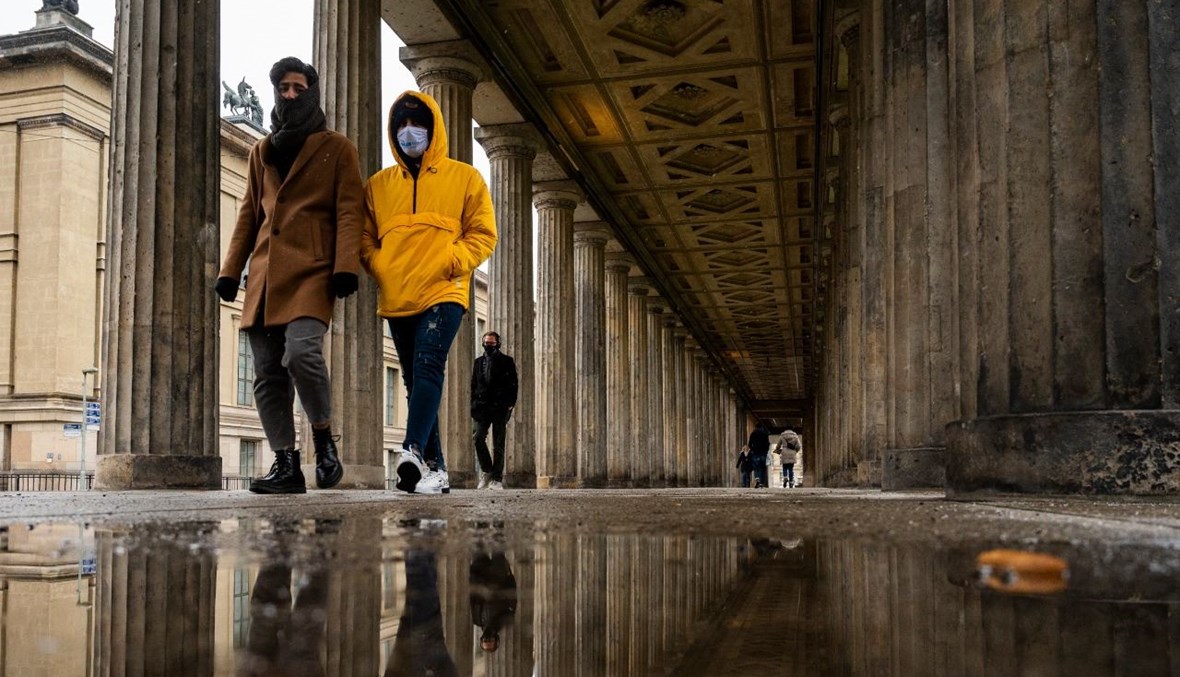أشخاص يمشون تحت أعمدة جزيرة المتاحف في برلين (15 ك2 2021، أ ف ب). 