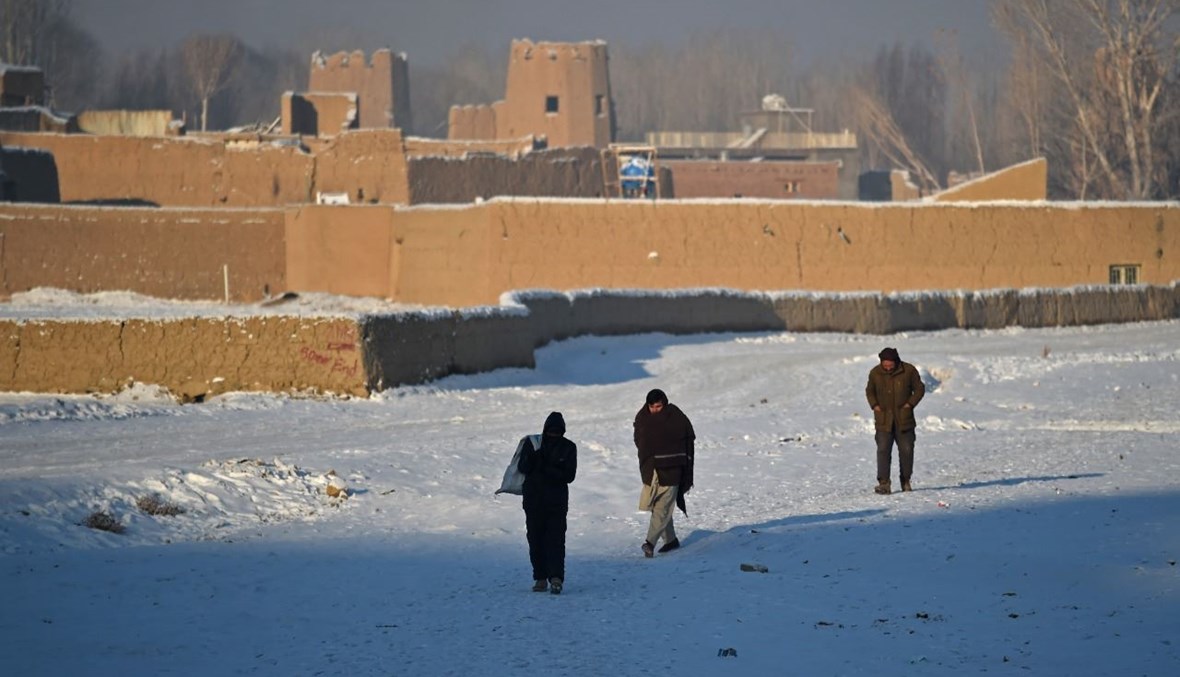 أشخاص يمشون على طريق غطتها الثلوج في مقاطعة باميان (8  ك2 2021، أ ف ب). 