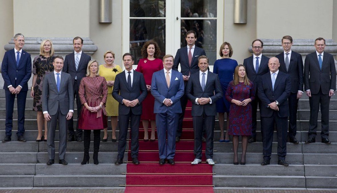 رئيس الوزراء الهولندي مارك روتي (الى اليسار في الوسط)، والملك الهولندي ويليم ألكسندر (في الوسط) يقفان مع الوزراء في صورة رسمية للحكومة الهولندية الجديدة على درجات القصر الملكي نوردايندي في لاهاي بهولندا (26 ت1 2017، أ ب). 