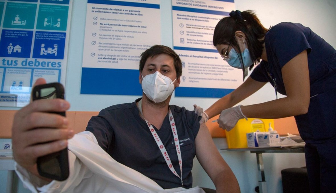 عامل صحي يتلقى لقاح كورونا في مستشفى بوستا سنترال في سانتياغو بتشيلي (15 ك2 2021، أ ف ب).