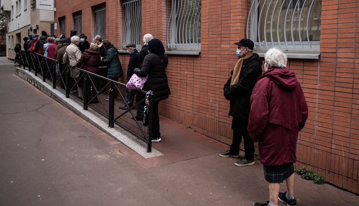 أشخاص انتظروا بالصف امام مركز تطعيم في باريس (15 ك2 2021، أ ف ب). 
