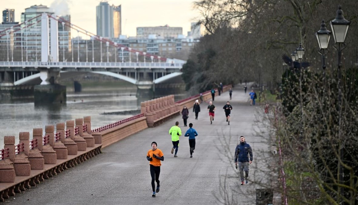 اشخاص يمارسون رياضة الركض بالقرب في حديقة باترسي في لندن (17 ك2 2021، أ ف ب). 