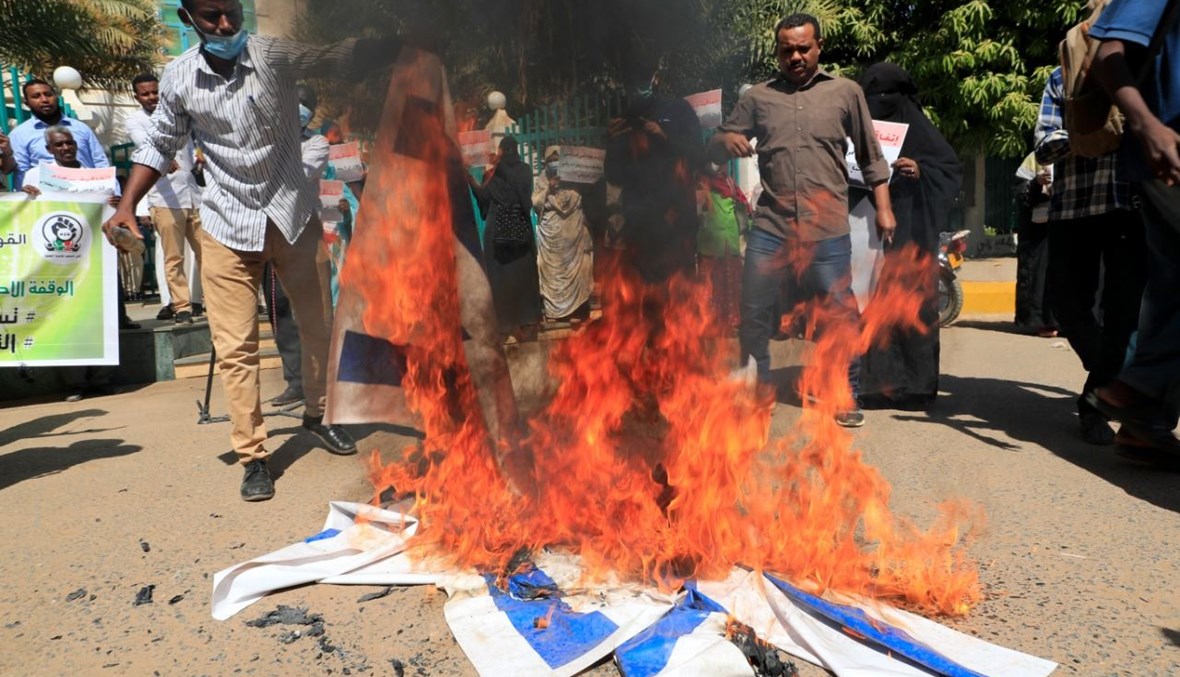 متظاهرون سودانيون يحرقون العلم الاسرائيلي في الخرطوم (17 ك2 2021، أ ف ب). 