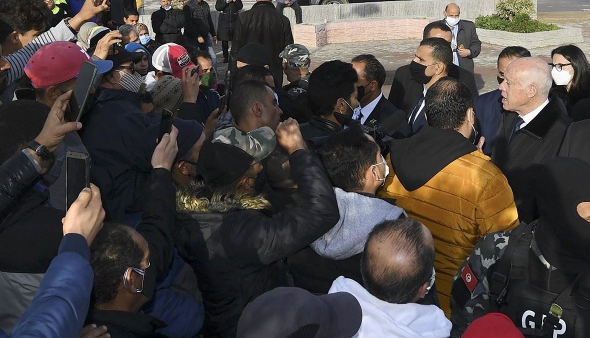 الرئيس التونسي قيس سعيد –الى اليمين-يتحدث إلى متظاهرين في حي المنيهلة بالعاصمة التونسية أمس .   (أ ف ب)