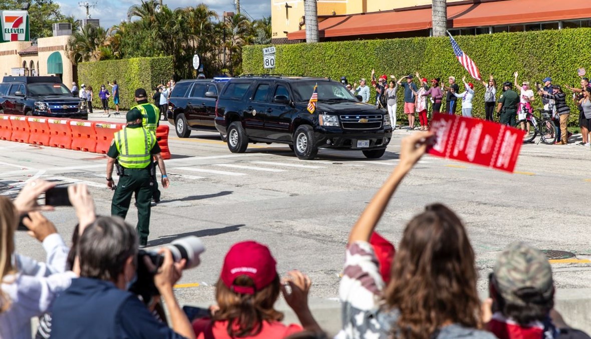 أنصار ترامب يلوحون له بينما يمر موكبه في طريقه إلى مار إيلاغو في فلوريدا (20 ك2 2021، أ ف ب).