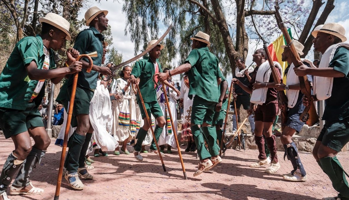 عرض درامي تقليدي وراقص في ساحة في مدينة غوندار بإثيوبيا خلال الاستعدادات لاحتفال "تيمكات"، عيد الغطاس الإثيوبي (17 ك2 2021، أ ف ب).