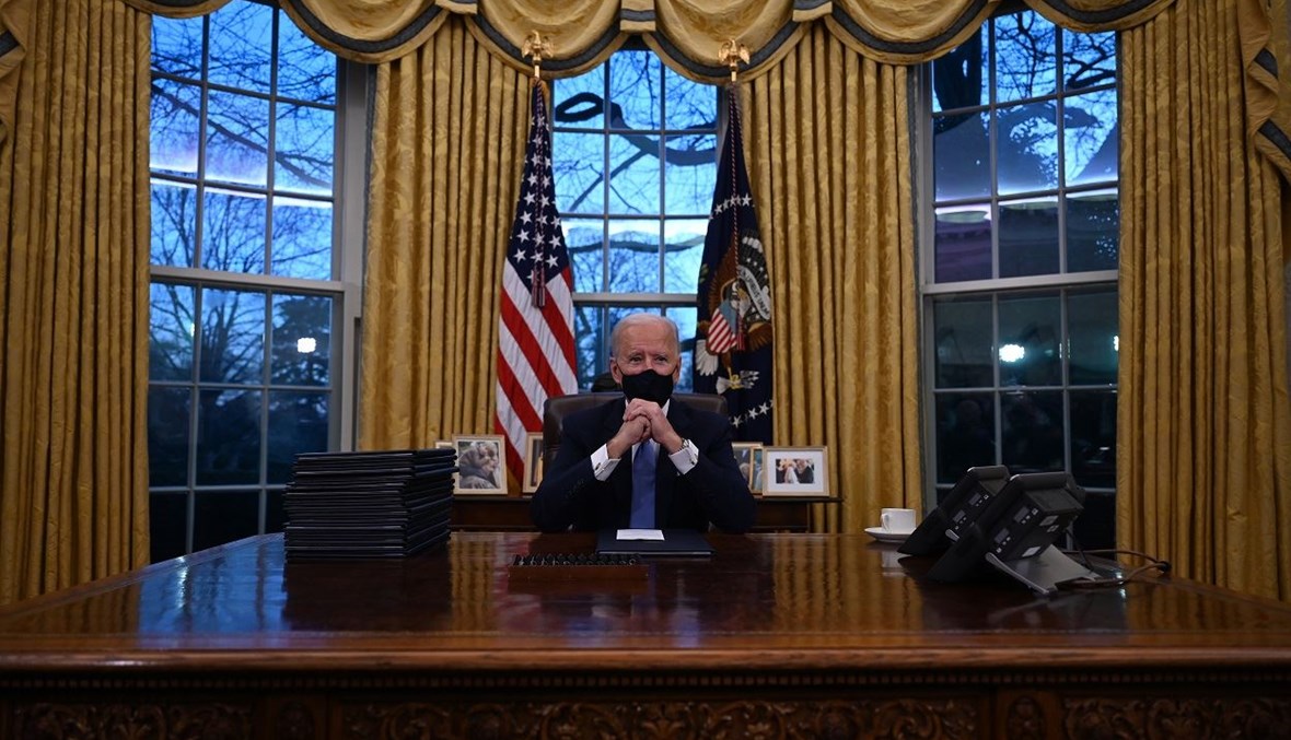 الرئيس الأميركي جو بايدن على طاولة المكتب البيضاوي في البيت الأبيض (أ ف ب).