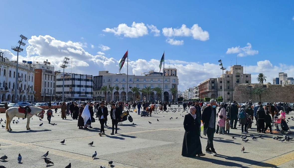 أشخاص يتمشون في ساحة الشهداء في طرابلس (19 ك2 2021، أ ف ب).
