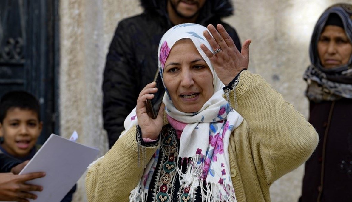 أمرأة تونسية تتحدث على الهاتف مع محامٍ لمعرفة مصير ابنها الذي اعتقل في الاحتجاجات الأخيرة في حي الكرم الغربي في إحدى ضواحي العاصمة التونسية.   (أ ف ب)