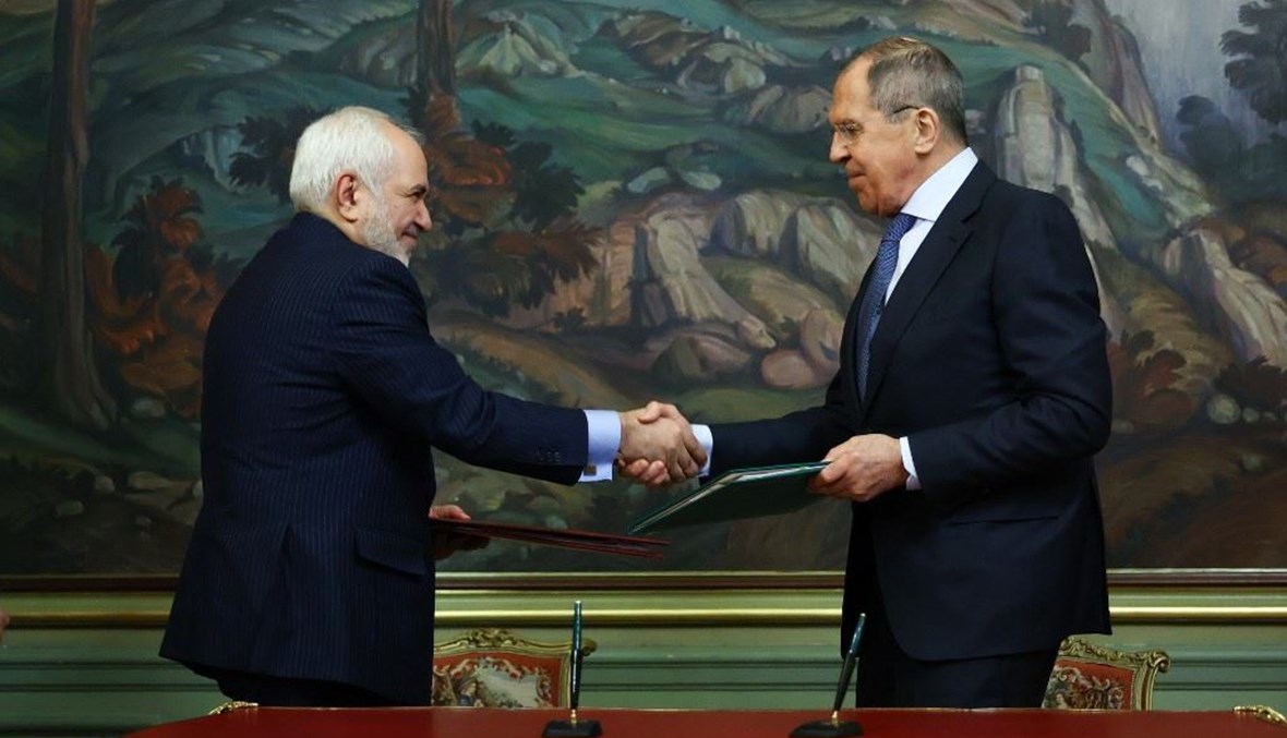 وزيرا الخارجية الروسي سيرغي لافروف - الى اليمين - والايراني محمد جواد ظريف يتبادلان الوثائق عقب التوقيع على وثائق في موسكو أمس.(أ ف ب)