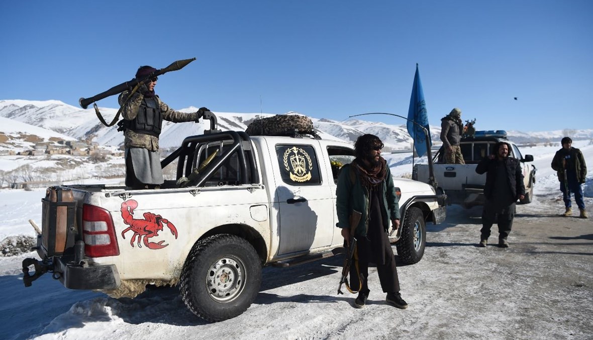 عناصر من مليشيات الهزارة المسلحة وقفوا على طريق أمام قاعدتهم خلال دورية ضد متمردي طالبان في منطقة حصة عوالي بهسود بإقليم ميدان وردك (9 ك2 2021، أ ف ب). 