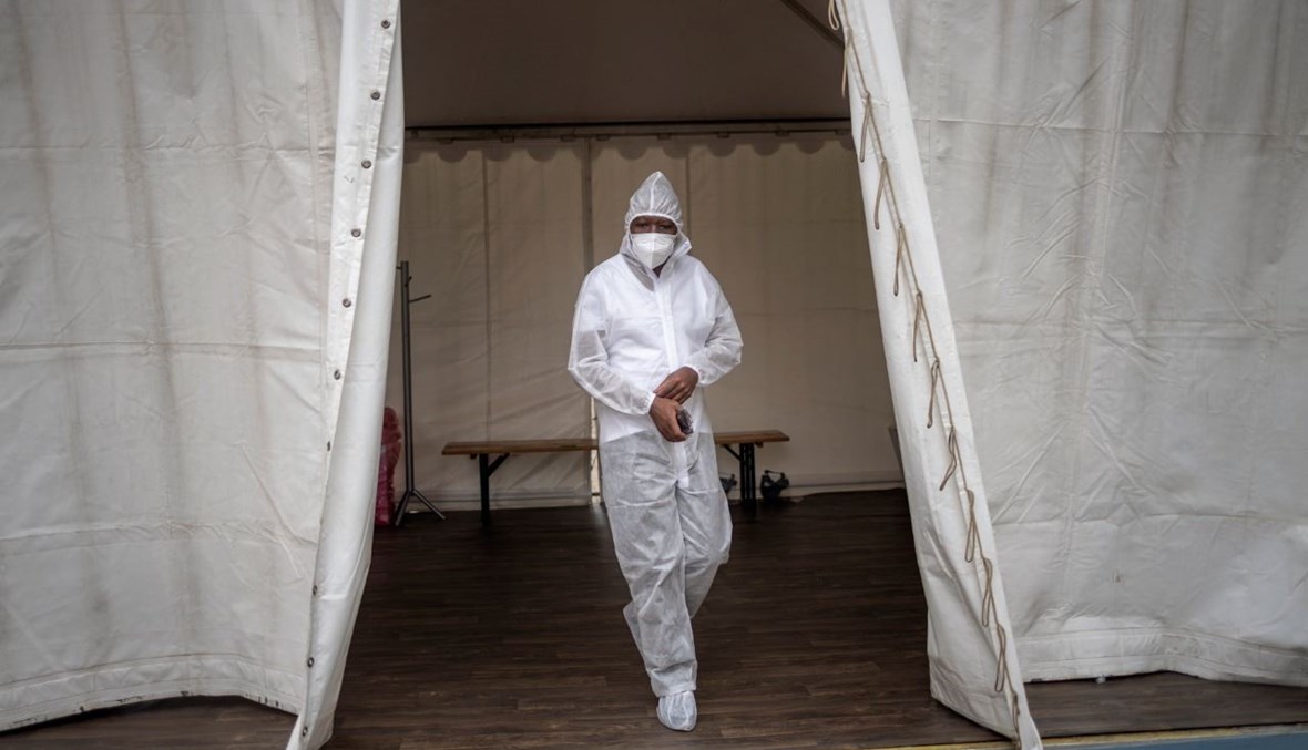عامل صحي يخرج من جناح مخصص لعلاج مرضى كورونا في مستشفى ناسريك الميداني في سويتو في جنوب افريقيا (25 ك2 2021، أ ف ب).