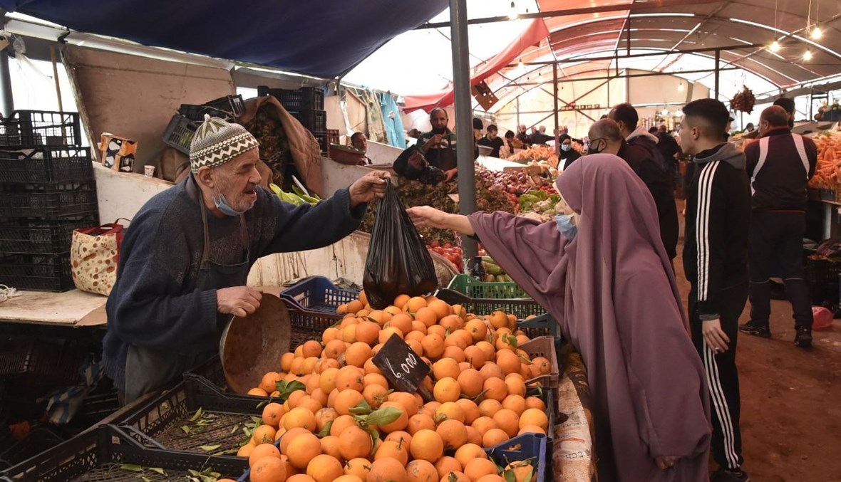 جزائريون يتسوقون في سوق في ضاحية باب الواد بالعاصمة الجزائرية )26 ك2 2021، أ ف ب). 