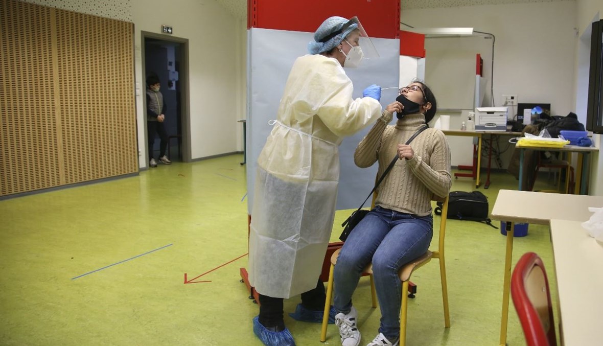 ممرضة تأخذ مسحة أنفية من تلميذة في مدرسة في فيكو بجزيرة كورسيكا الفرنسية (29 ك2 2021، أ ف ب).