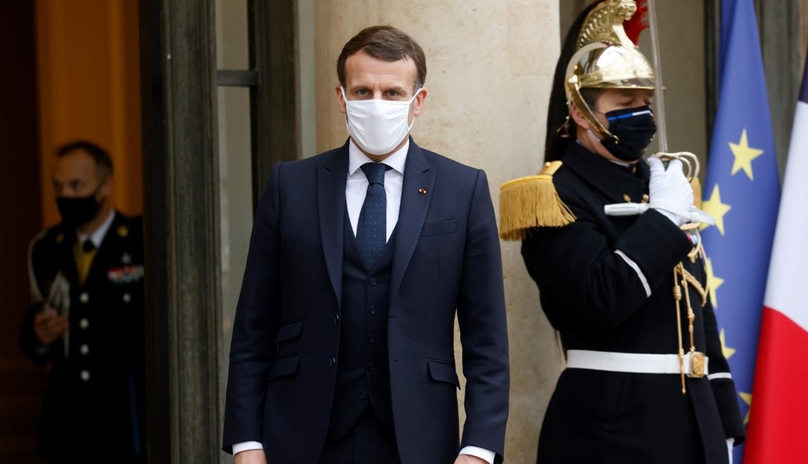 ماكرون يقف عند مدخل قصر الاليزيه في باريس، بعد غداء عمل مع الرئيس الانتقالي لمالي الانتقالي (27 ك2 2021، أ ف ب). 