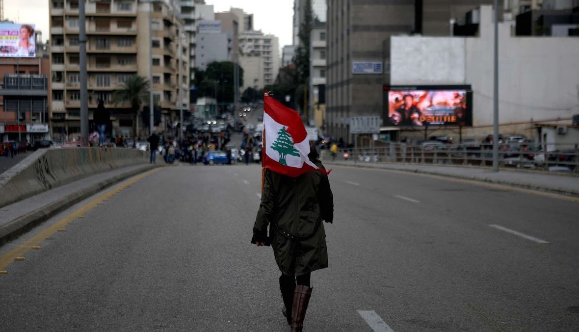 متظاهرة تحمل علم لبنان في بيروت (أرشيفية - أ ف ب).