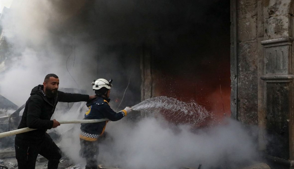 عمال إنقاذ يطفئون حريقًا اندلع من دراء انفجار في بلدة اعزاز بالريف الشمالي لحلب (31 ك2 2021، أ ف ب). 