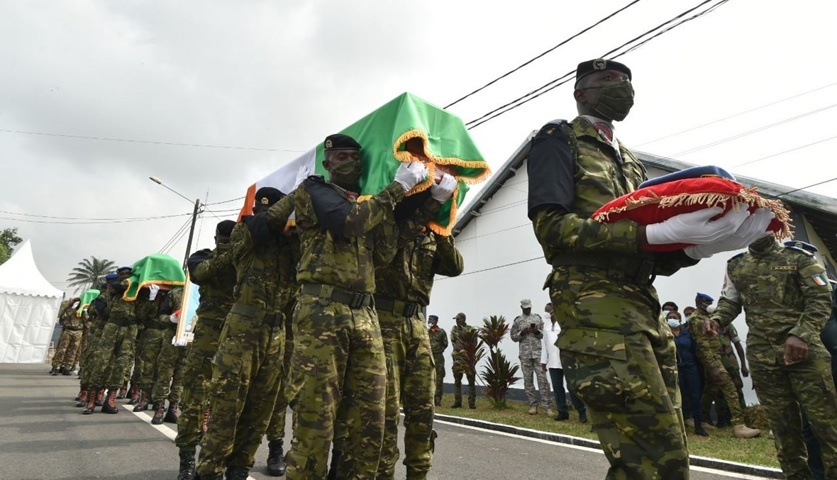 جنود من ساحل العاج يحملون نعوش جنود ايفواريين من قوة مينوسما قتلوا في مالي، وذلك خلال مراسم تكريمية، في مقر الجيش في أبيدجان (25 ك2 2021، أ ف ب).