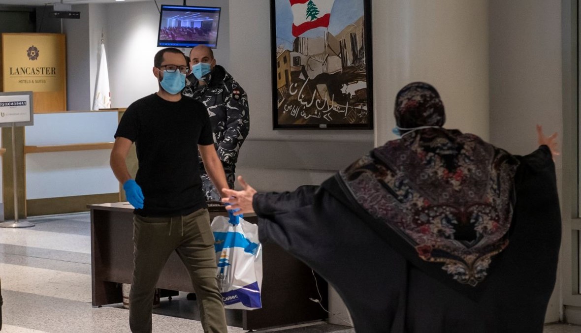 سيدة لبنانية في المطار تفتح ذراعيها لاستقبال نجلها العائد من الامارات بعد اطلاقه. 