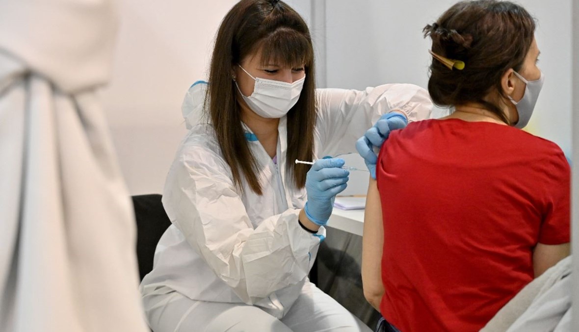 امرأة تتلقى جرعة من لقاح "سبوتنيك في" الروسي في معرض بلغراد في بلغراد بعد تحويله مركزا للتطعيم (4 شباط 2021، أ ف ب).