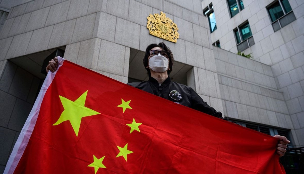 رجل يحمل علم الصين خلال احتجاج لنشطاء مؤيدين لبيجينغ امام القنصلية العامة البريطانية في هونغ كونغ (1 شباط 2021، أ ف ب). 