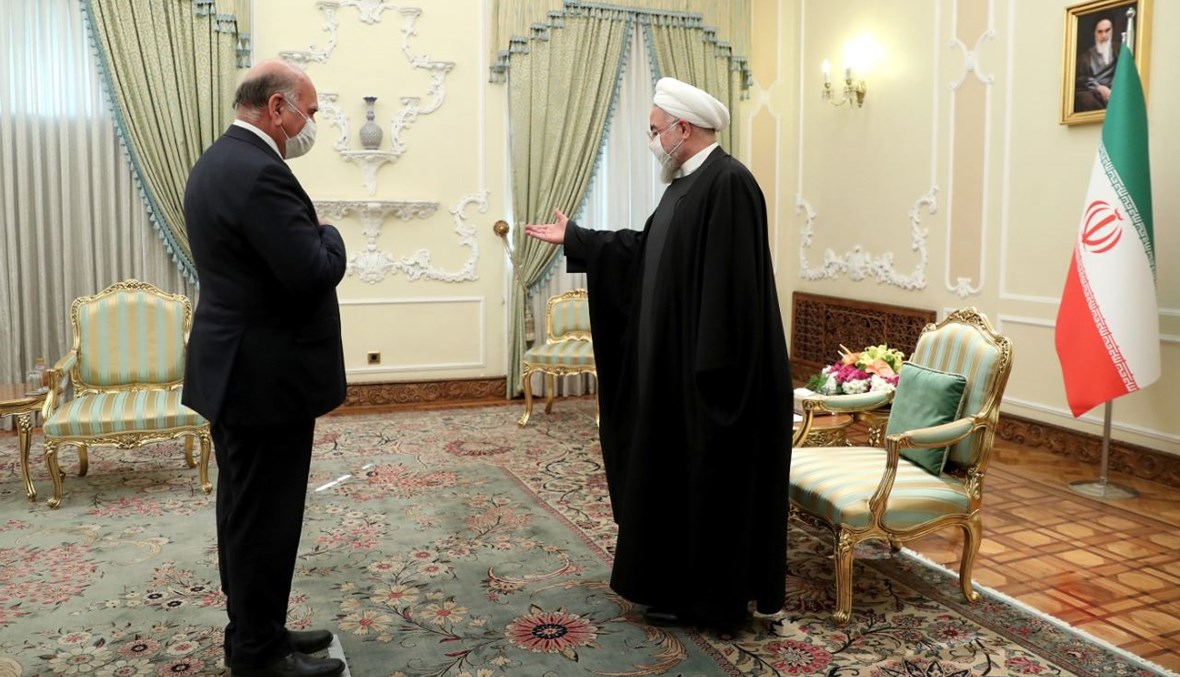 الرئيس روحاني مستقبلا وزير الخارجية العراقي فؤاد حسين في طهران (3 شباط 2021، أ ف ب).