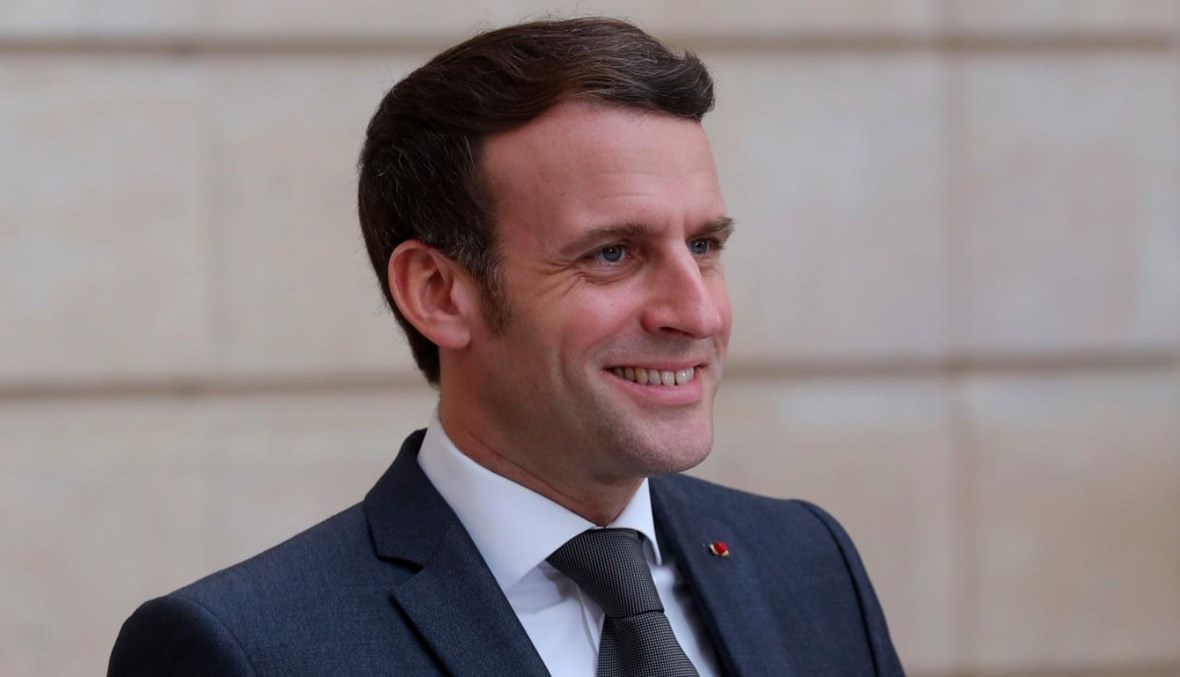 ماكرون مبتسما بعد اجتماع بميركل، عبر الفيديو، في قصر الإليزيه في باريس (5 شباط 2021، أ ف ب).