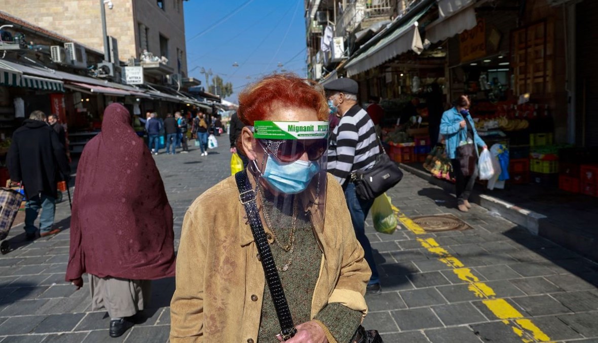 أشخاص يتسوقون في سوق في القدس (7 شباط 2021، أ ف ب).