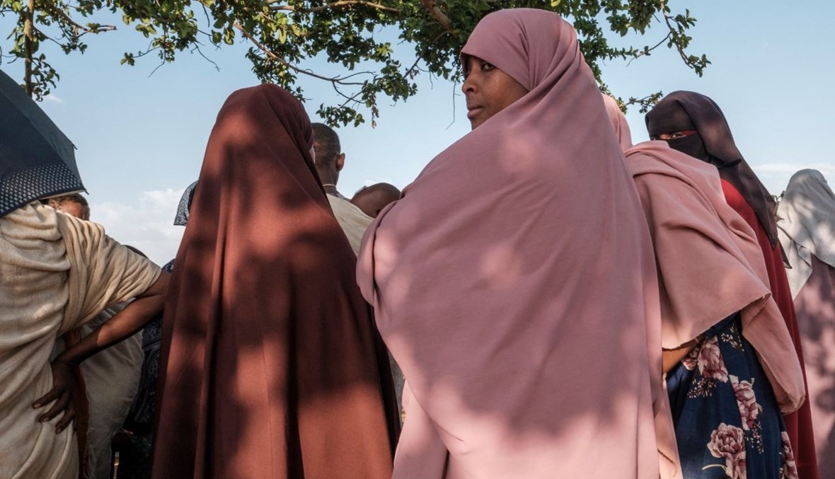 نازحون فارون من العنف في منطقة ميتيكل في غرب إثيوبيا تجمعوا تحت شجرة في مخيم في تشاغني بإثيوبيا (27 ك2 2021، أ ف ب).