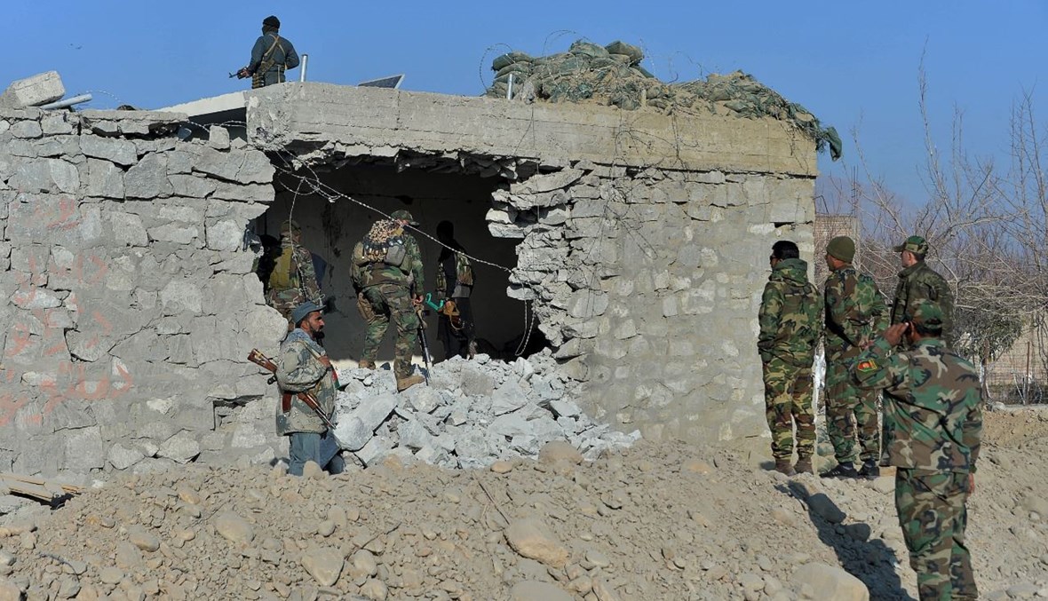 عناصر من قوات الأمن الأفغانية في موقع انفجار بسيارة مفخخة في منطقة خوجياني بمحافظة ننجرهار (7 شباط 2021، أ ف ب). 