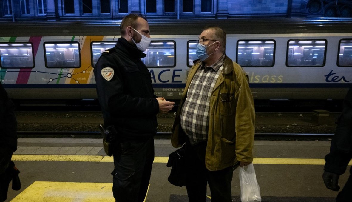 عناصر من شرطة الحدود الألمانية والفرنسية يتحدثون إلى الركاب في محطة قطارات في ستراسبورغ شرق فرنسا (4 شباط 2021، أ ف ب).