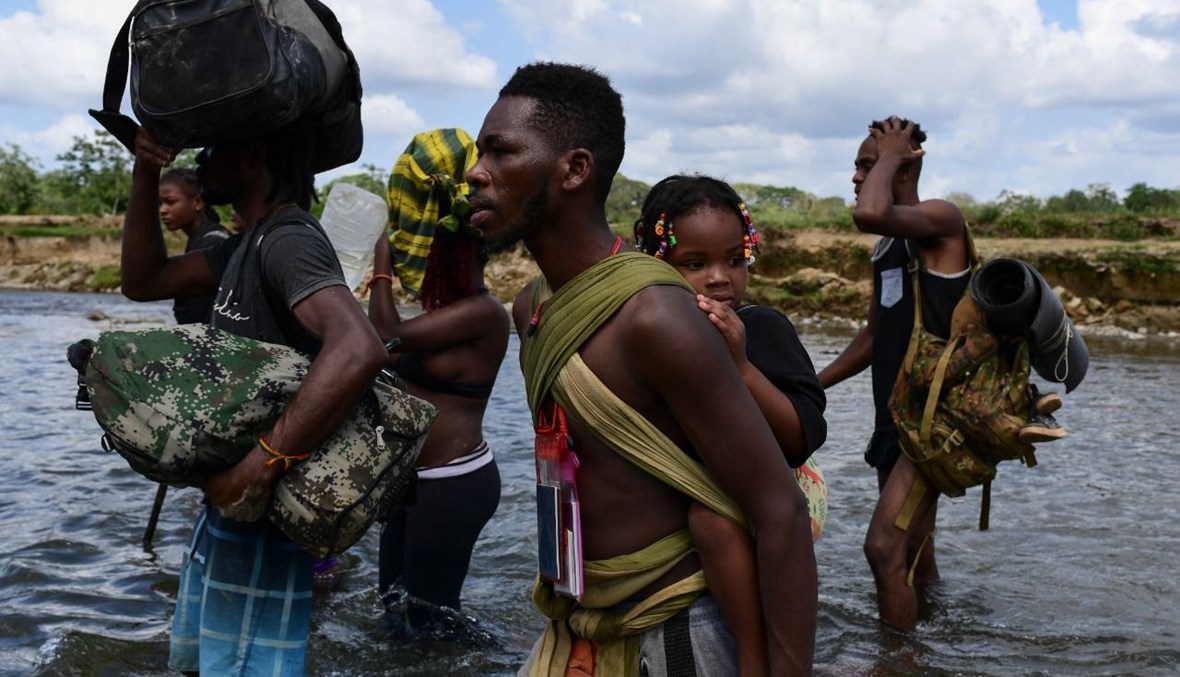 مهاجرون يعبرون نهر تشوكوناك بعد المشي لمدة خمسة أيام في دارين غاب في قرية باجو تشيكيتو في مقاطعة دارين في بنما (10 شباط 2021، أ ف ب). 
