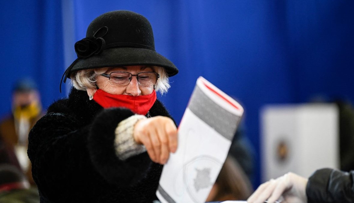 امرأة من ألبان كوسوفو تدلي بصوتها في مركز اقتراع في بريشتينا )14 شباط 2021، أ ف ب).