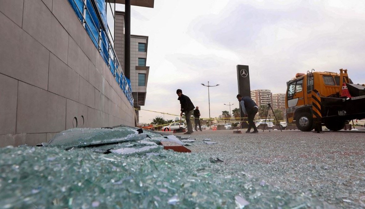 عامل ينظف الزجاج المتكسر من جراء سقوط صواريخ على قاعدة للتحالف في مدينة اربيل ليل الإثنين.(أ ف ب)