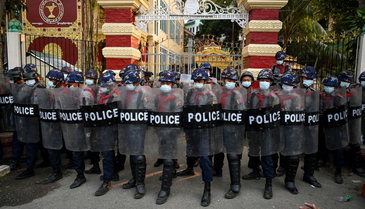 عناصر من الشرطة شكلوا حاجزا عند مدخل دير بوذي حيث لجأ مؤيدون للجيش بعد اشتباكات مع السكان المحليين في يانغون (18 شباط 2021، أ ف ب).