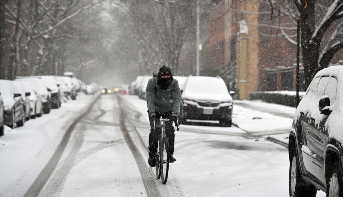 شخص يقود دراجته في شارع غطته الثلوج في بروكلين في نيويورك (18 شباط 2021، أ ف ب).