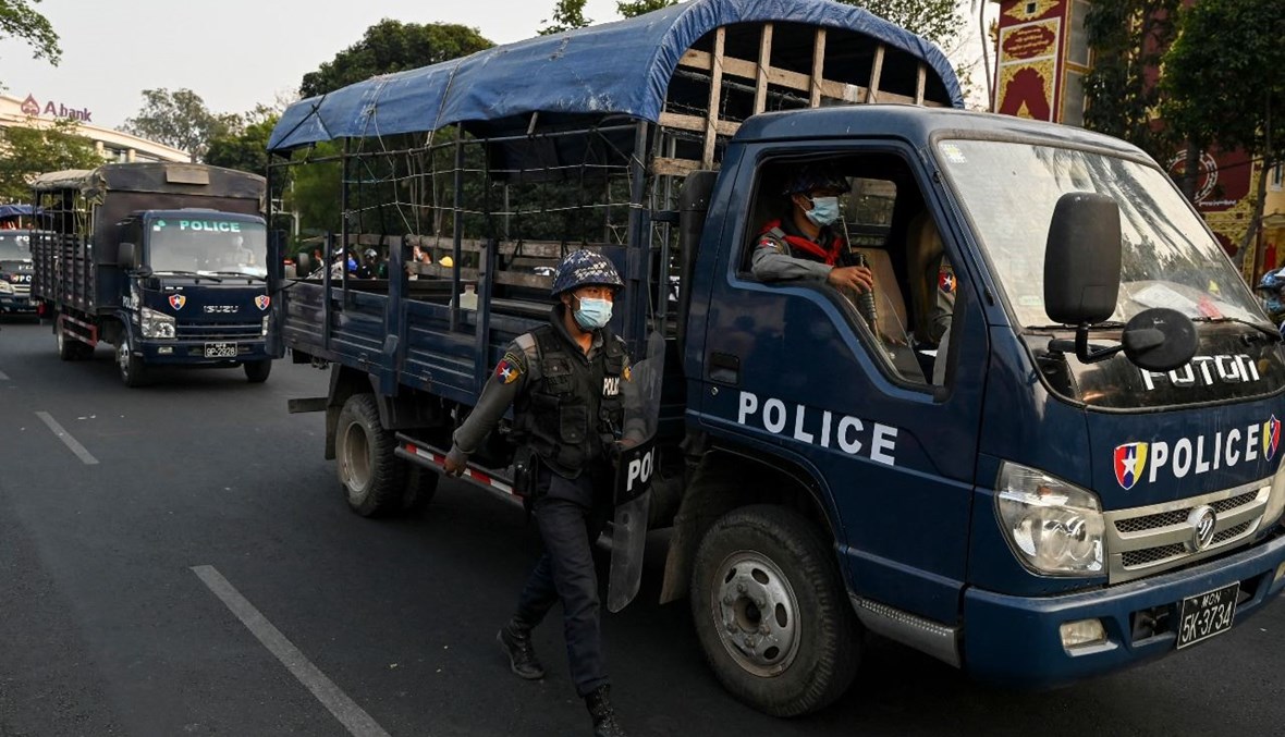 عناصر من الشرطة توقفوا بالقرب من دير بوذي حيث لجأ مؤيدون للجيش بعد اشتباكات مع السكان المحليين في يانغون (18 شباط 2021، أ ف ب).