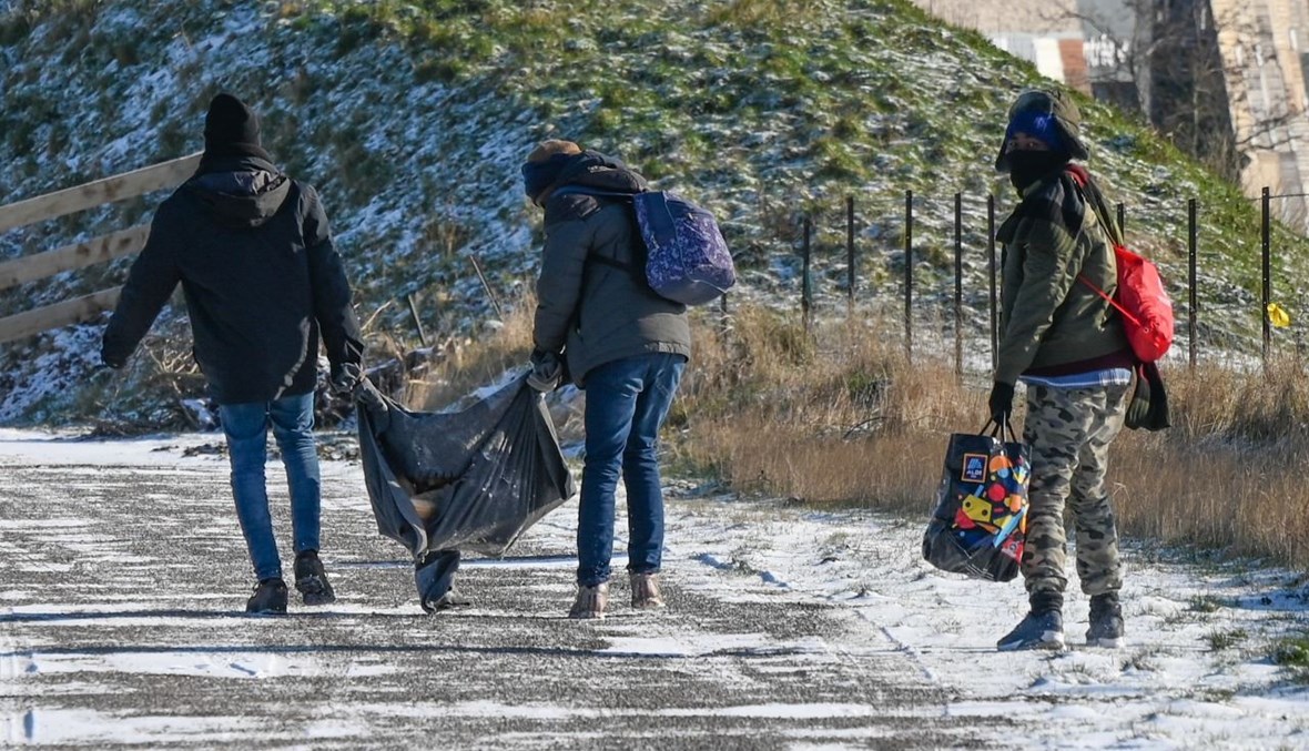 مهاجرون خلال توجههم للحصول على وجبات توزعها الجمعيات في كاليه شمال فرنسا (9 شباط 2021، أ ف ب).