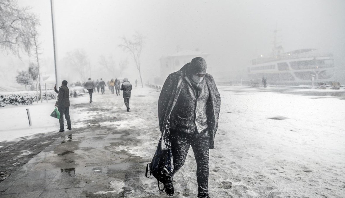 رجل يمشي تحت الثلوج في منطقة كاديكوي في اسطنبول (17 شباط 2021، أ ف ب).