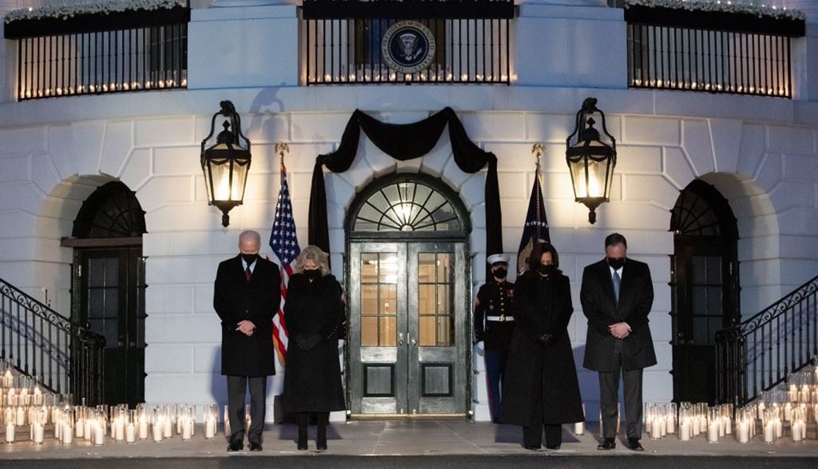 بايدن وزوجته وهاريس وزوجها يقفون دقيقة صمت حداداً على ضحايا الجائحة في البيت الأبيض (أ ف ب).