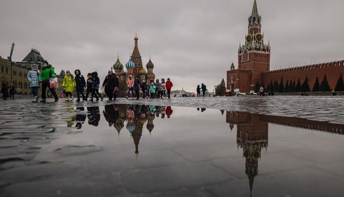 أطفال يمشون في الساحة الحمراء في موسكو. وبدا في الخلفية برج سباسكايا في الكرملين وكاتدرائية القديس باسيل (26 شباط 2021، أ ف ب). 