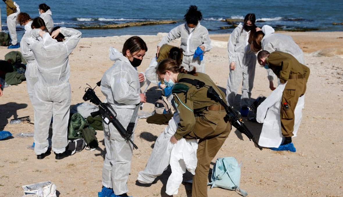 جنود إسرائيليون يستعدون لتنظيف شاطئ شارون الوطني الملوث شمال مدينة تل أبيب (22 شباط 2021، أ ف ب).