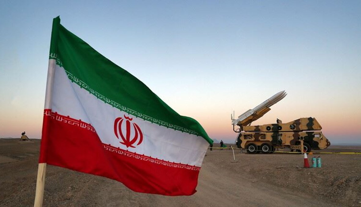 علم إيراني أمام راجمة صواريخ في صورة من الارشيف.