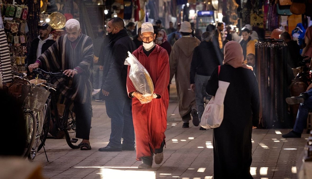 مغاربة يمشون في مدينة مراكش القديمة (24 شباط 2021، أ ف ب).