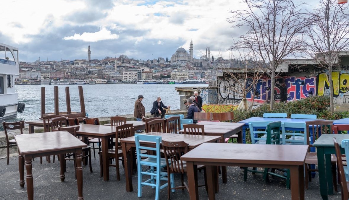 أشخاص جلسوا في مطعم بجانب البحر في كاراكوي في اسطنبول (2 آذار 2021، أ ف ب).