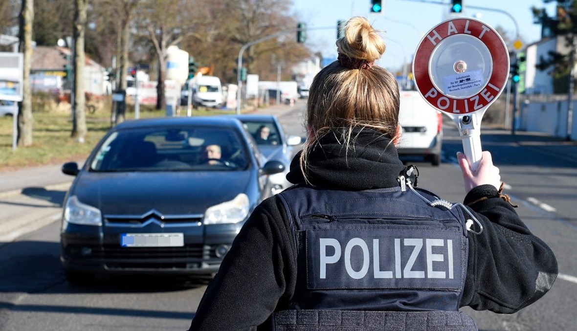 شرطية ألمانية تقف عند نقطة تفتيش للسيارات في ساربروكن   بألمانيا (23 شباط 2021، أ ف ب). 