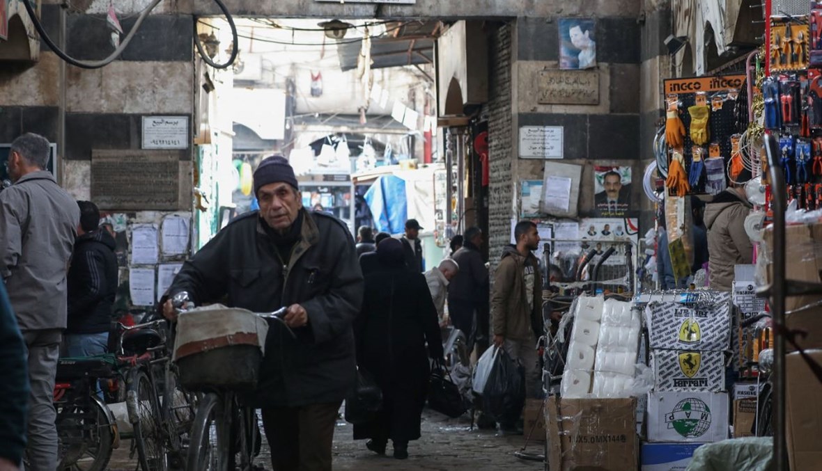سوريون يمشون في باب الفرج في بلدة دمشق القديمة (2 آذار 2021، أ ف ب).
